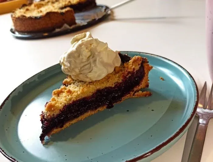 Stück Blaubeerkuchen mit Sahne auf einem Teller