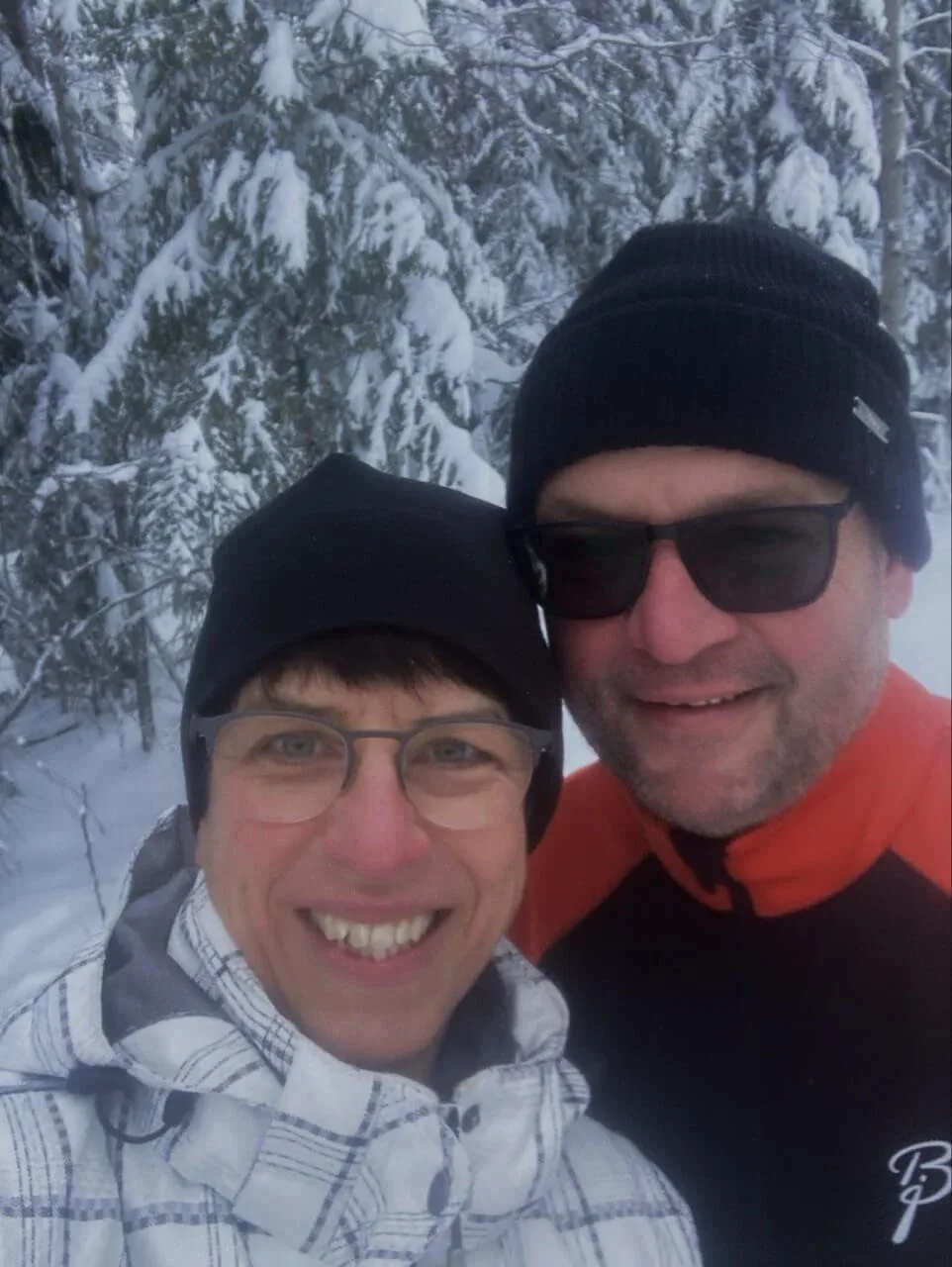Zwei Gäste in Wintermützen im Schnee