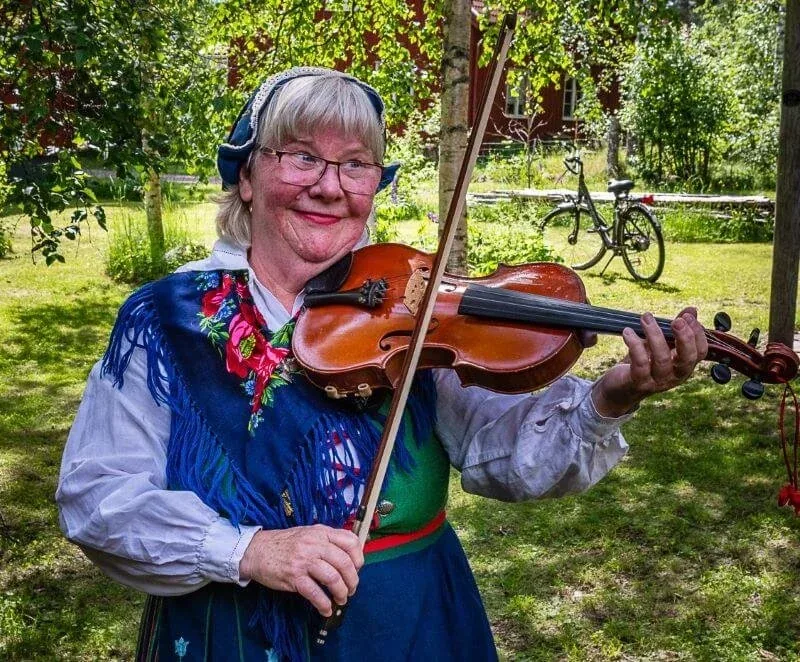 Frau in Tracht spielt Geige
