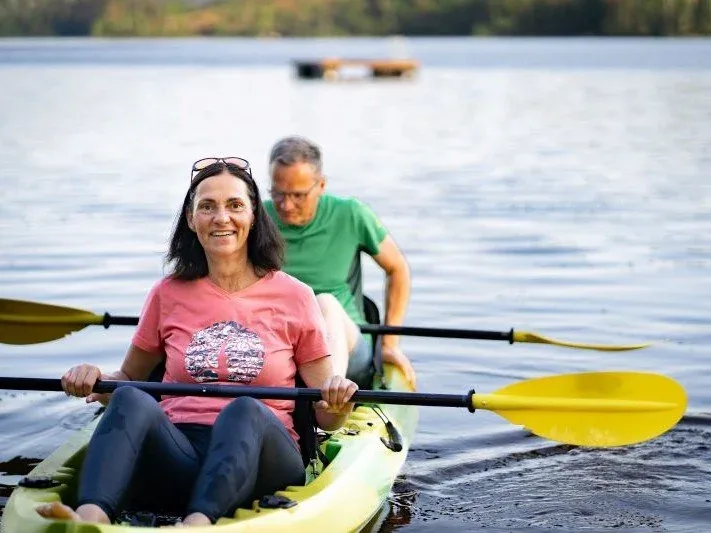 Zwei Personen paddeln im Kajak über den See