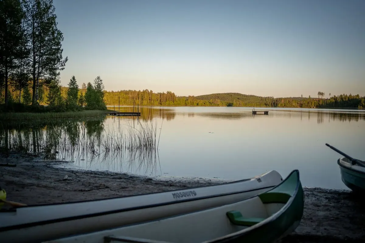 Ufer mit Kanus und Booten im Abendlicht