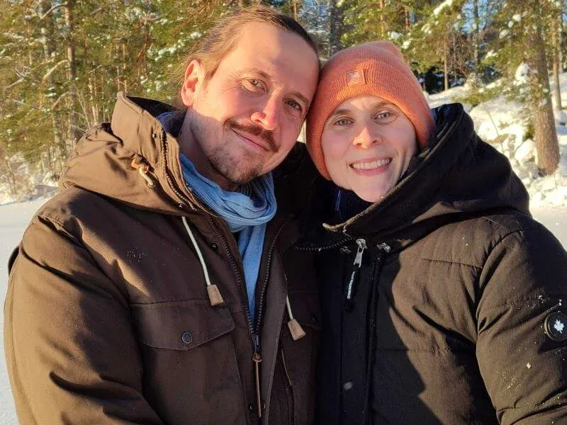 Zwei Gäste in Winterjacken lächeln in die Kamera