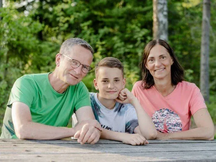 Rainer, Henri und Nicole am Holztisch im Garten