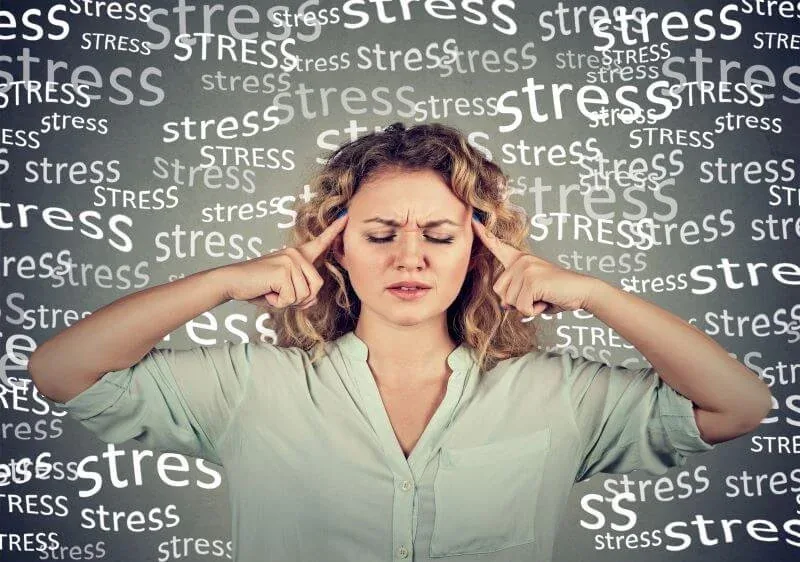 Frau hält sich die Ohren zu, umgeben vom Wort „stress“