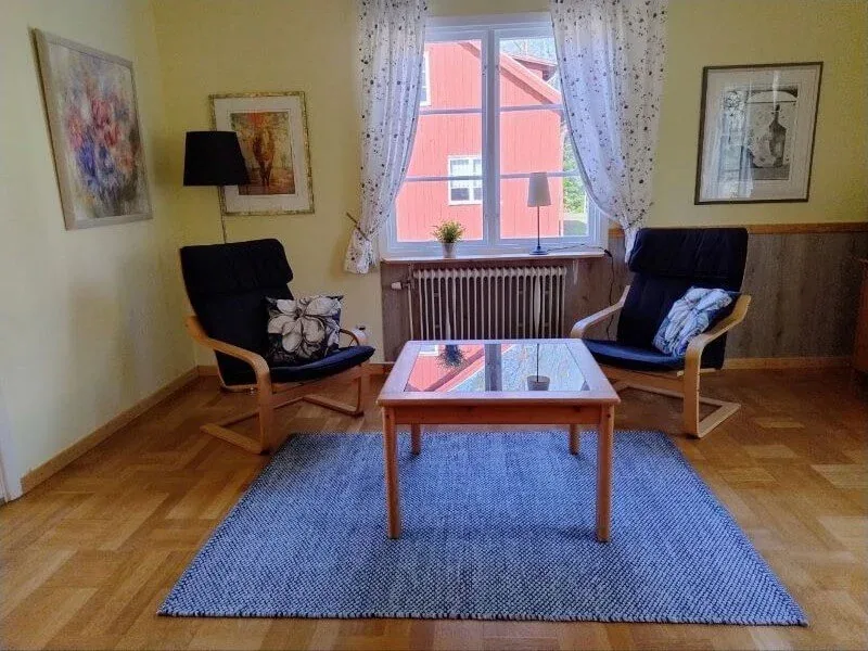 Wohnzimmer mit zwei Sesseln, Couchtisch und Blick aus dem Fenster