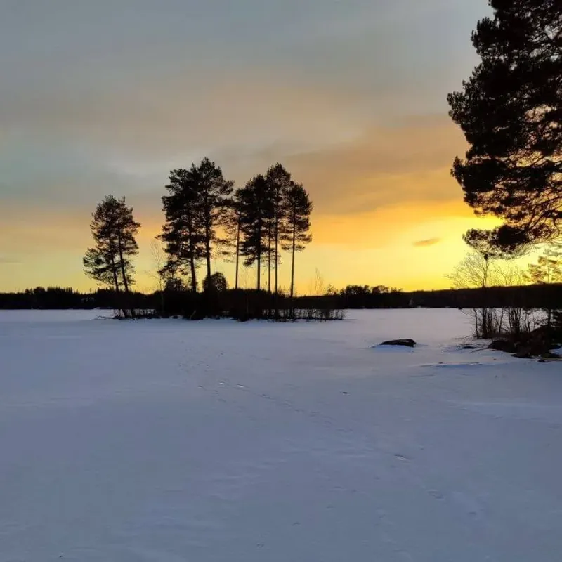 Sonnenuntergang über dem verschneiten See