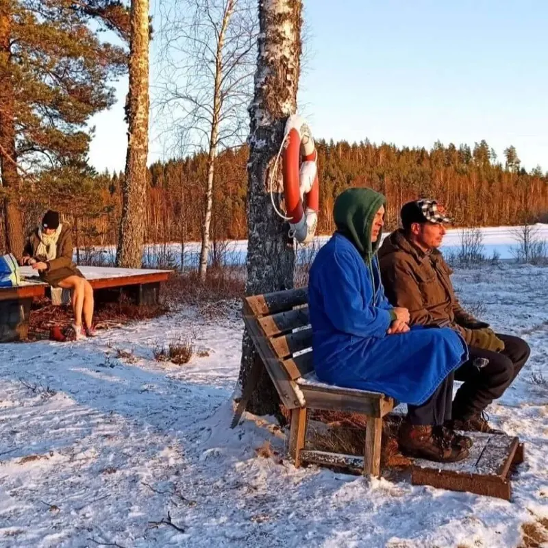 Zwei Menschen in Decken gehüllt sitzen in der Wintersonne
