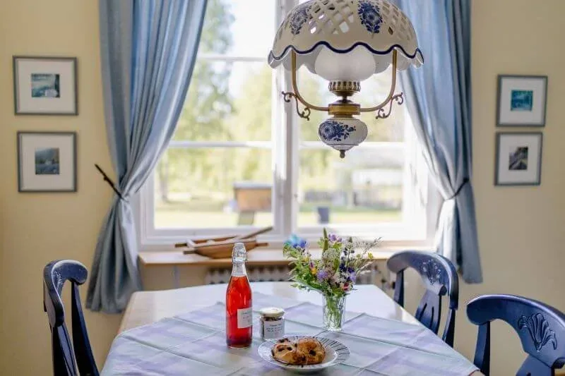 Esstisch am Fenster mit blauen Vorhängen