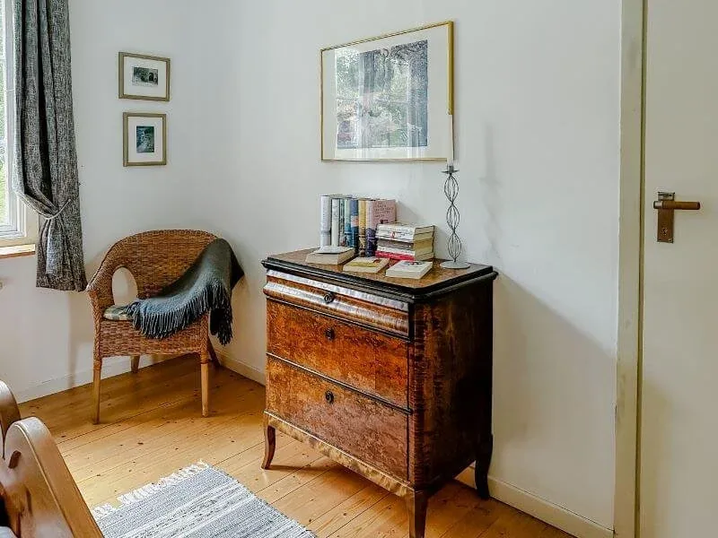 Zimmer mit Kommode und Sessel