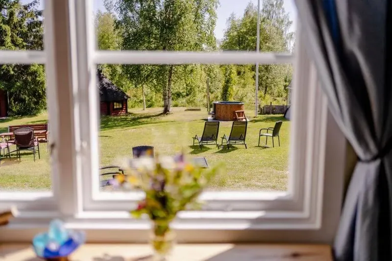 Blick aus dem Fenster auf den Garten mit Blumenstrauß