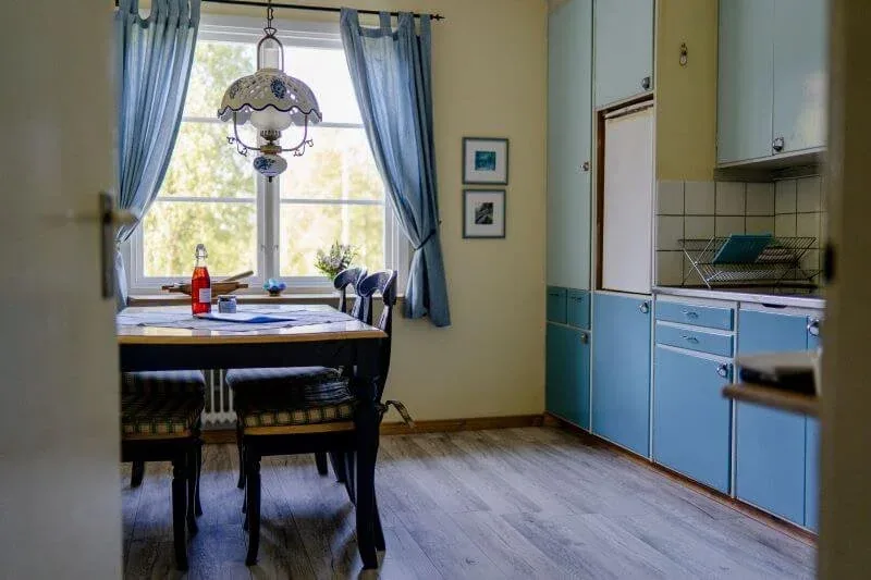 Küche mit blauen Schränken und Esstisch